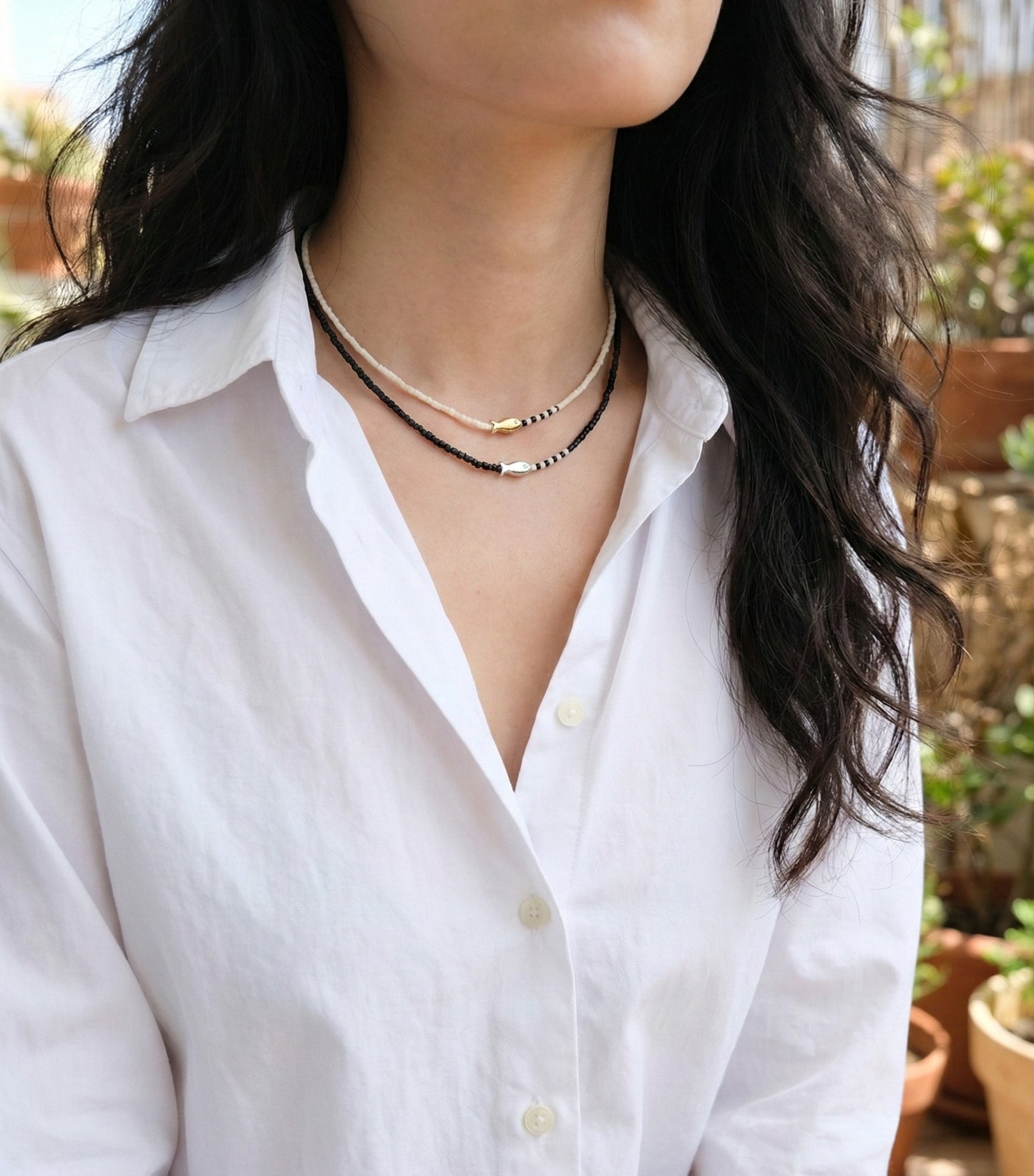  Black and ivory seed bead fish necklaces layered on woman monochrome minimalist jewelry style 