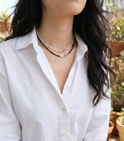  Black and ivory seed bead fish necklaces layered on woman monochrome minimalist jewelry style 