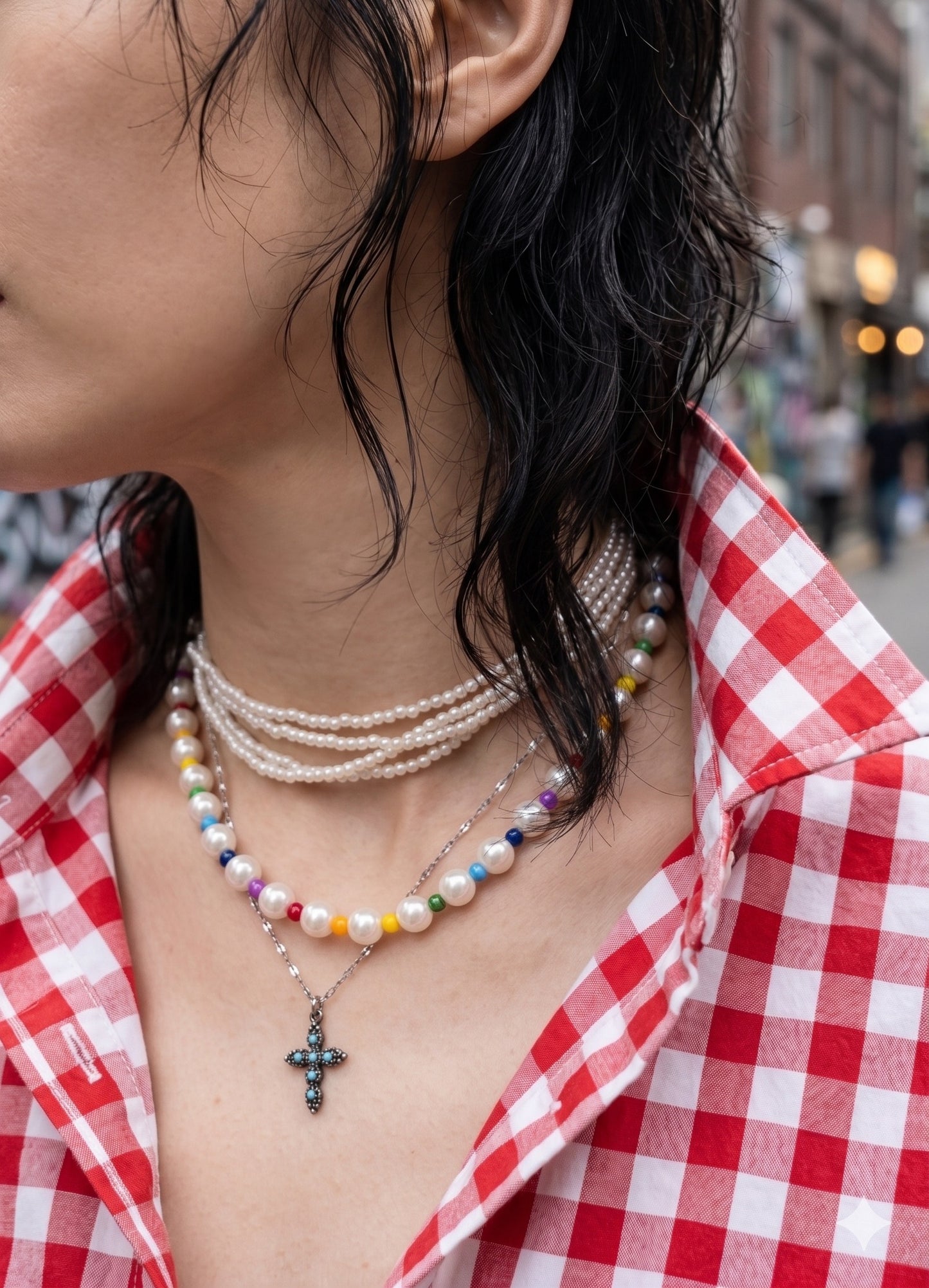Maximalist neck mess inspo, 5-strand mini pearl choker stacked with rainbow bead necklace and cross pendant.