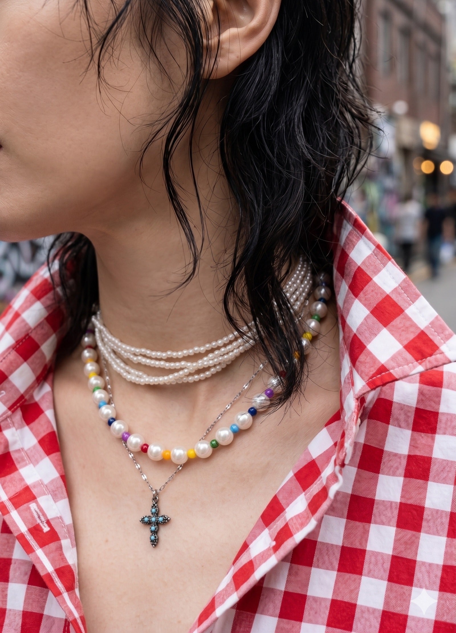Maximalist neck mess inspo, 5-strand mini pearl choker stacked with rainbow bead necklace and cross pendant.