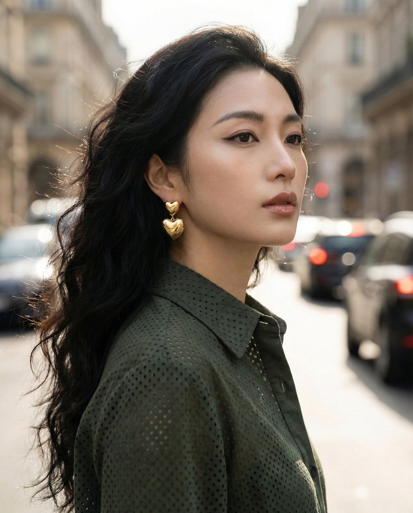 Gold puffed heart earrings in natural sunlight - bokeh background