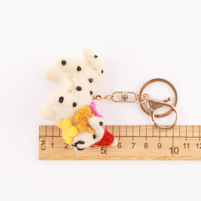 Size reference photo showing wool felt Dalmatian keychain next to wooden ruler measuring approximately 8cm