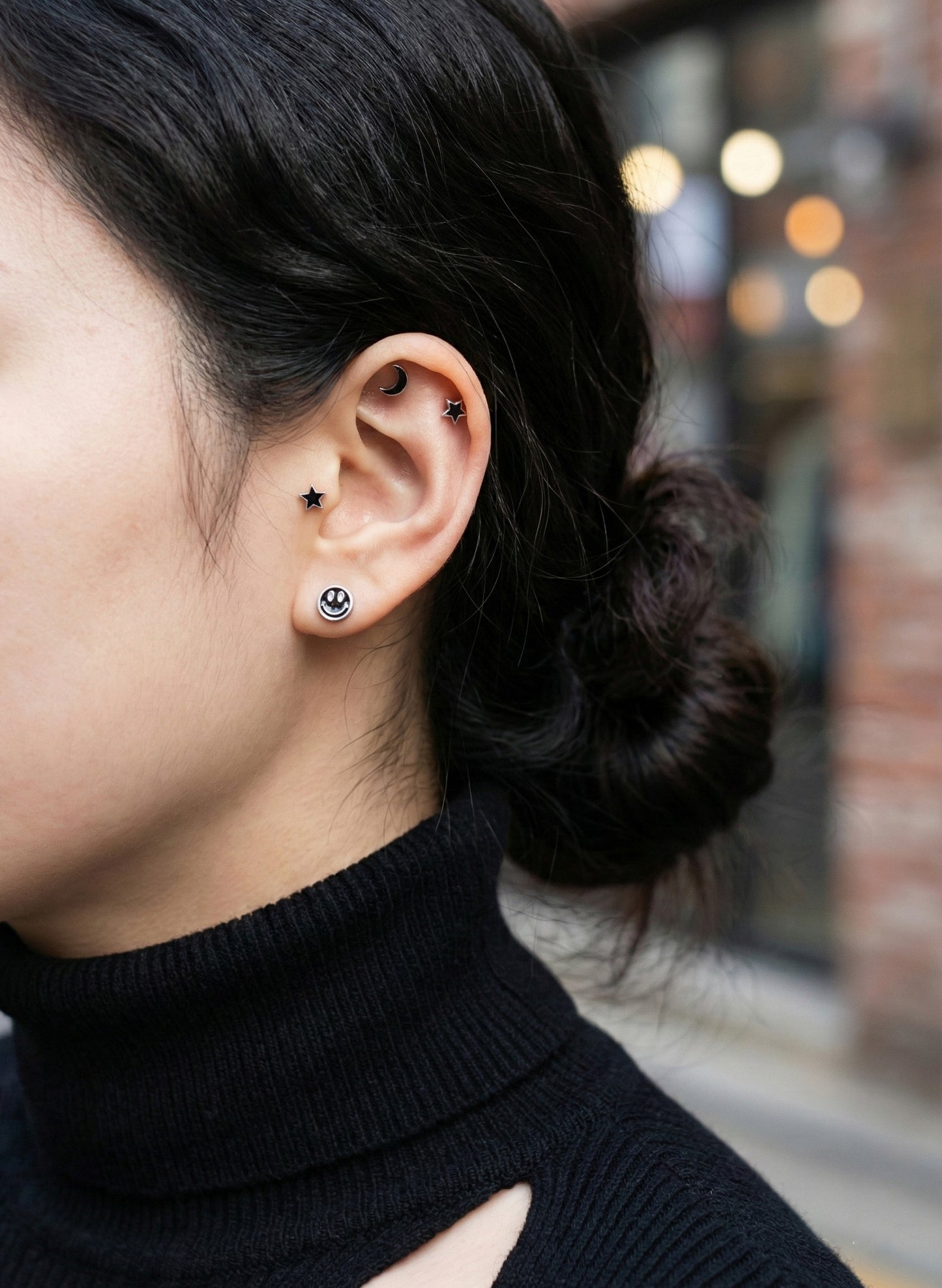 Real-life ear styling with smiley lobe piercing and moon tragus piercing