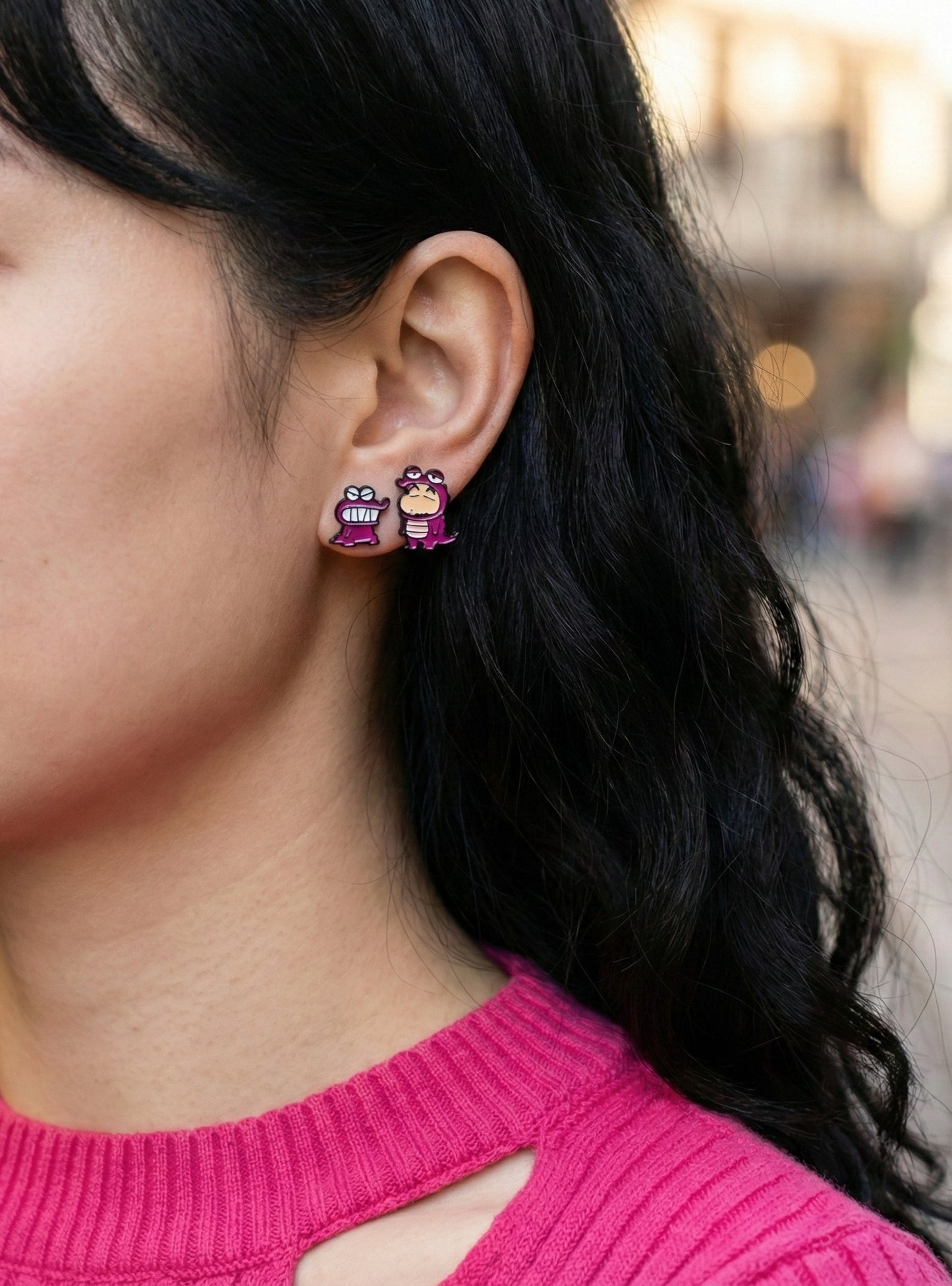 Model wearing pink Chocobi dinosaur and Shin-chan earrings outdoor shot with natural lighting and pink sweater