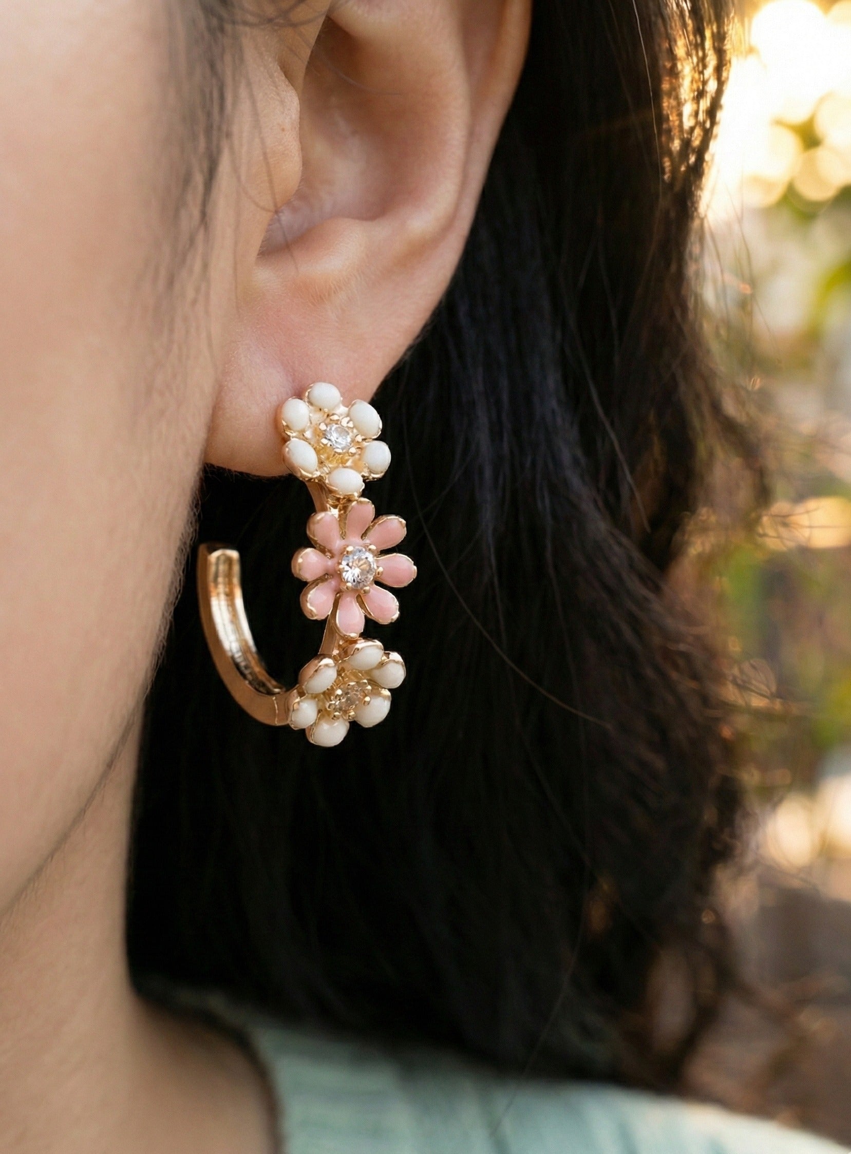 Model wearing peach blossom enamel flower hoop earrings front-side angle