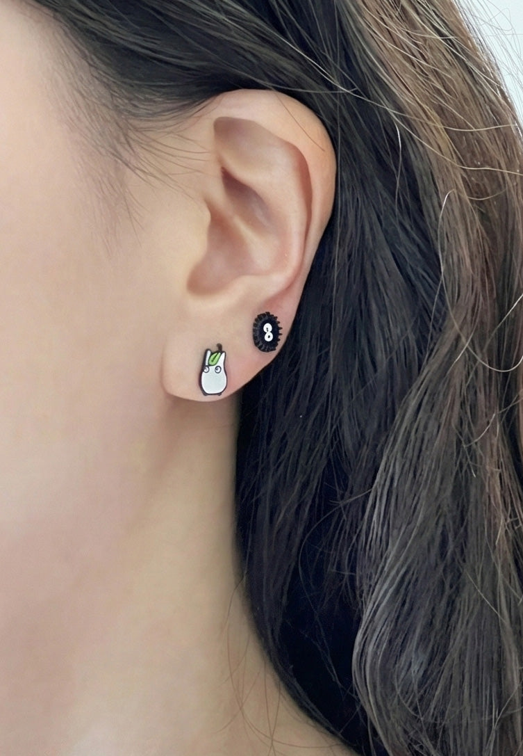 Soot sprite and white spirit studs worn together on ear
