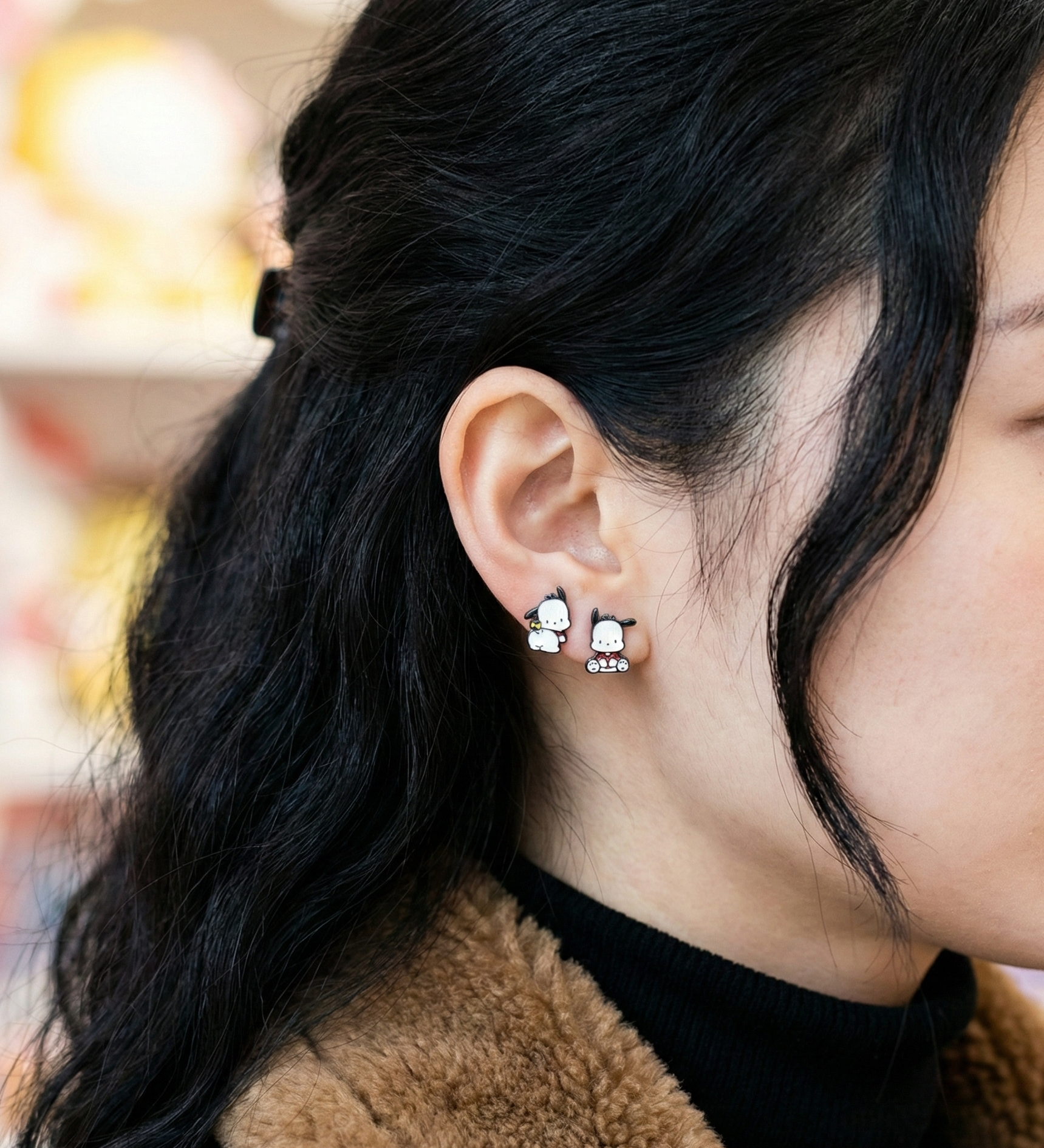  Side view of Pochacco dog earrings on ear with brown fleece jacket and black top