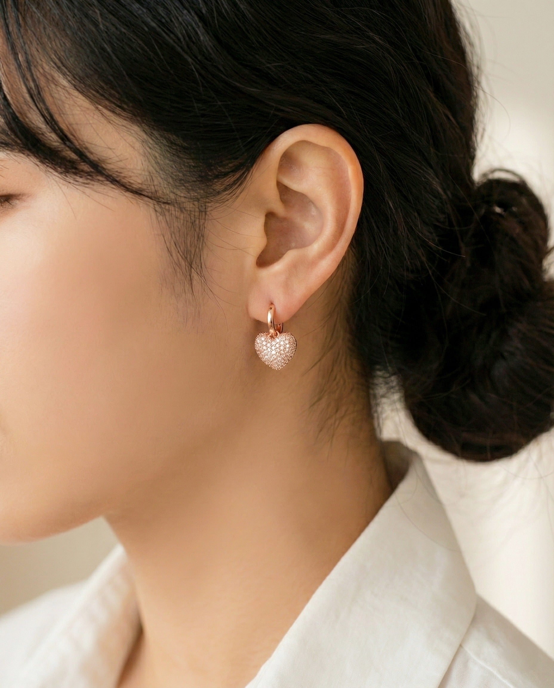 Rose gold pave heart earrings worn by model demonstrating romantic feminine style