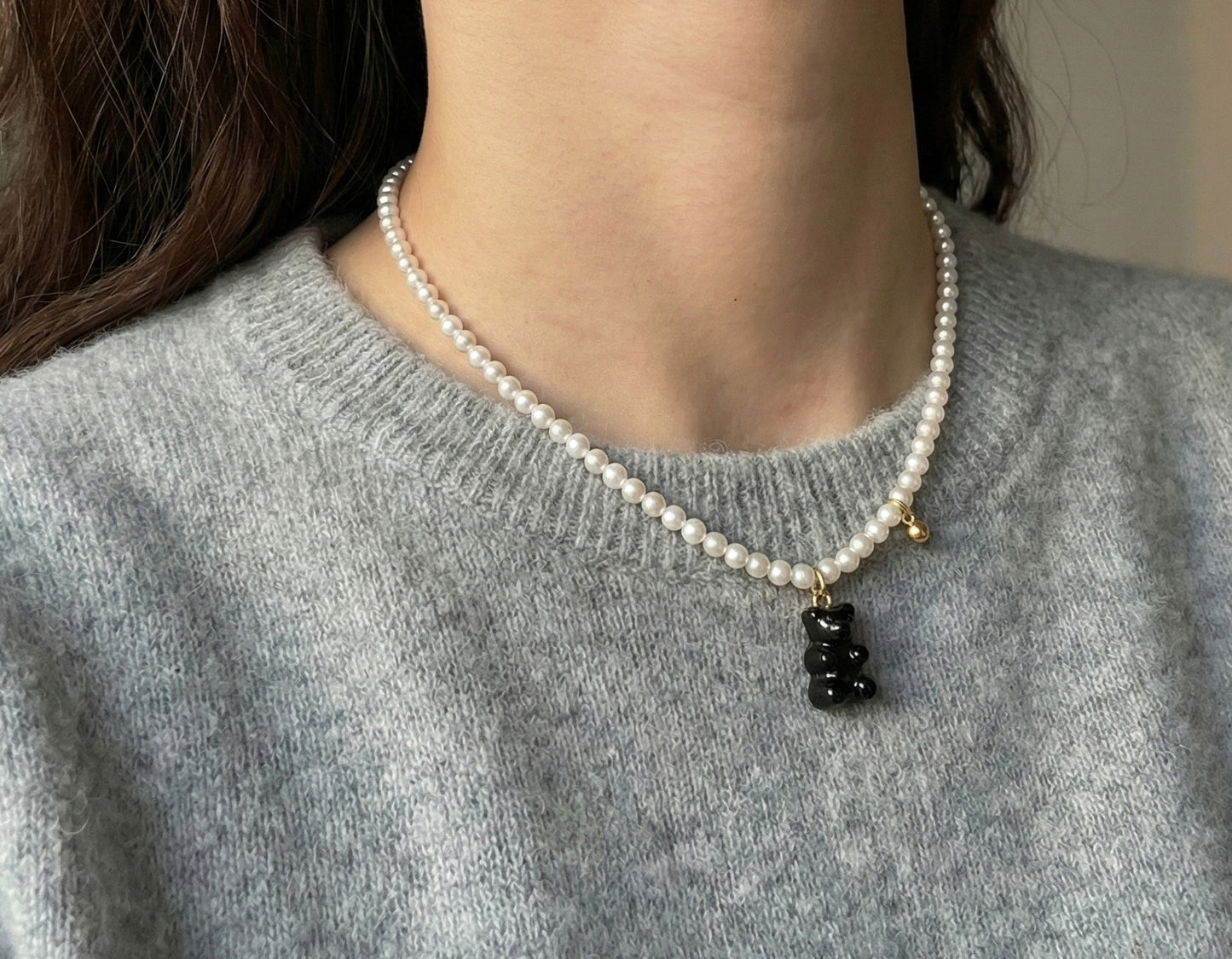 Woman wearing black gummy bear Swarovski pearl necklace close-up shot