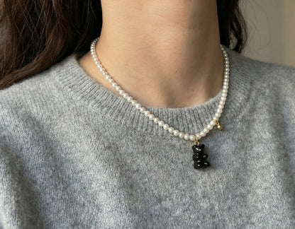 Woman wearing black gummy bear Swarovski pearl necklace close-up shot