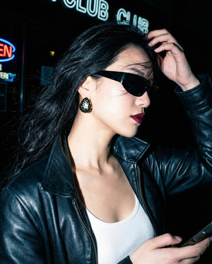 Edgy night look with leopard heart earrings leather jacket and bold makeup