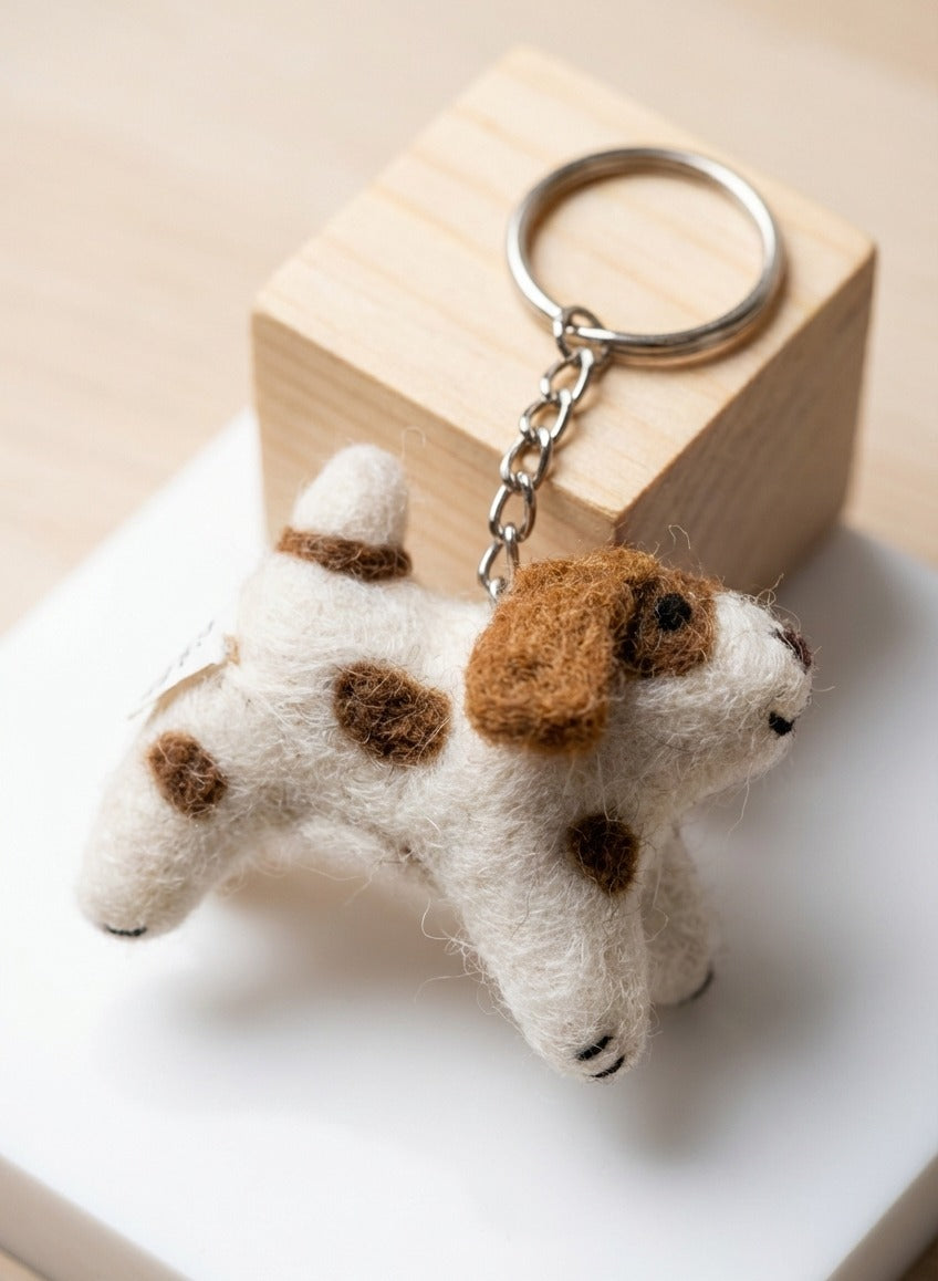 Close-up of needle felted puppy keychain with brown spots and metal chain