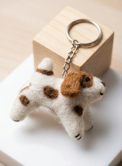 Close-up of needle felted puppy keychain with brown spots and metal chain