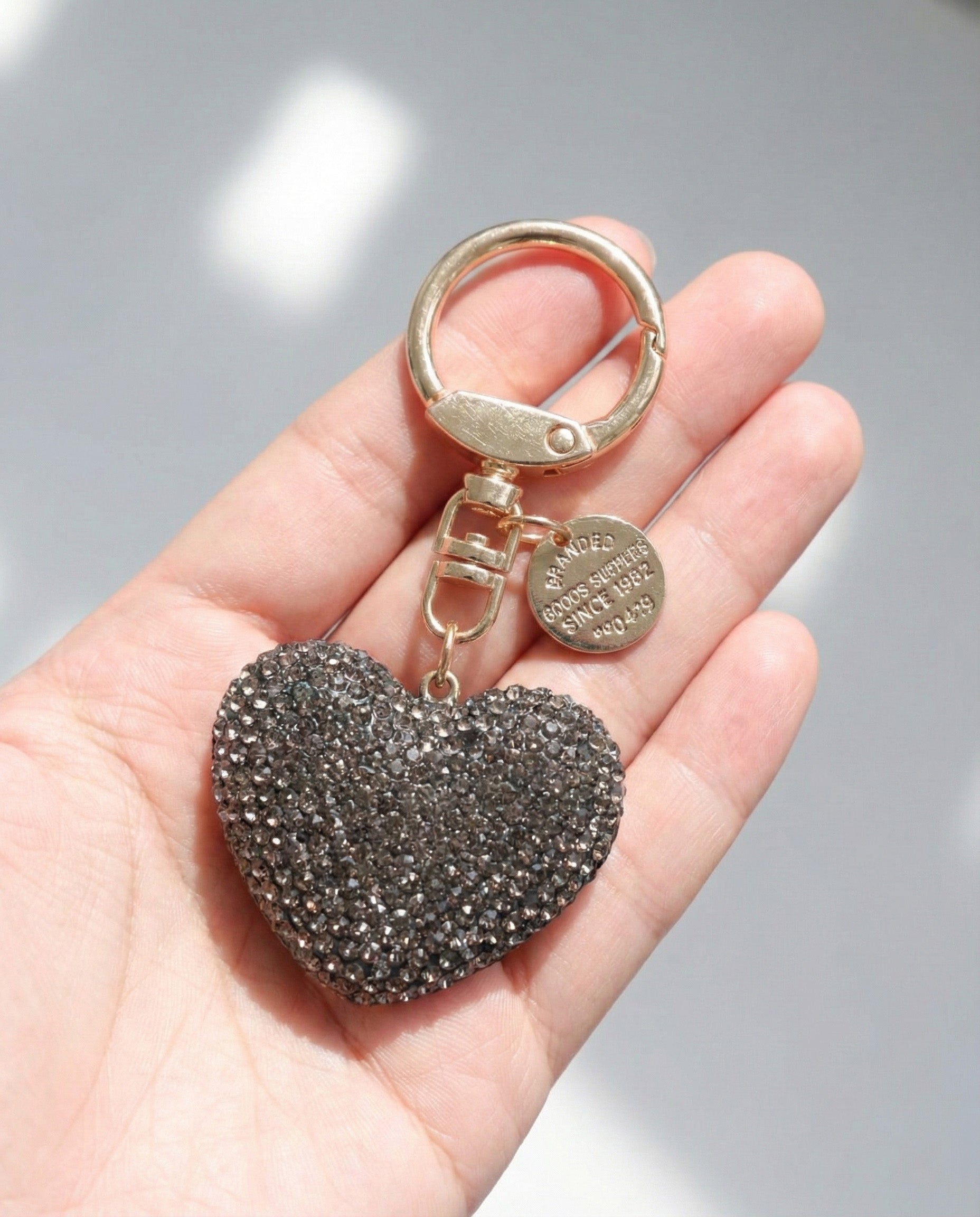 Gray rhinestone heart keychain in hand gold clasp bag charm size reference