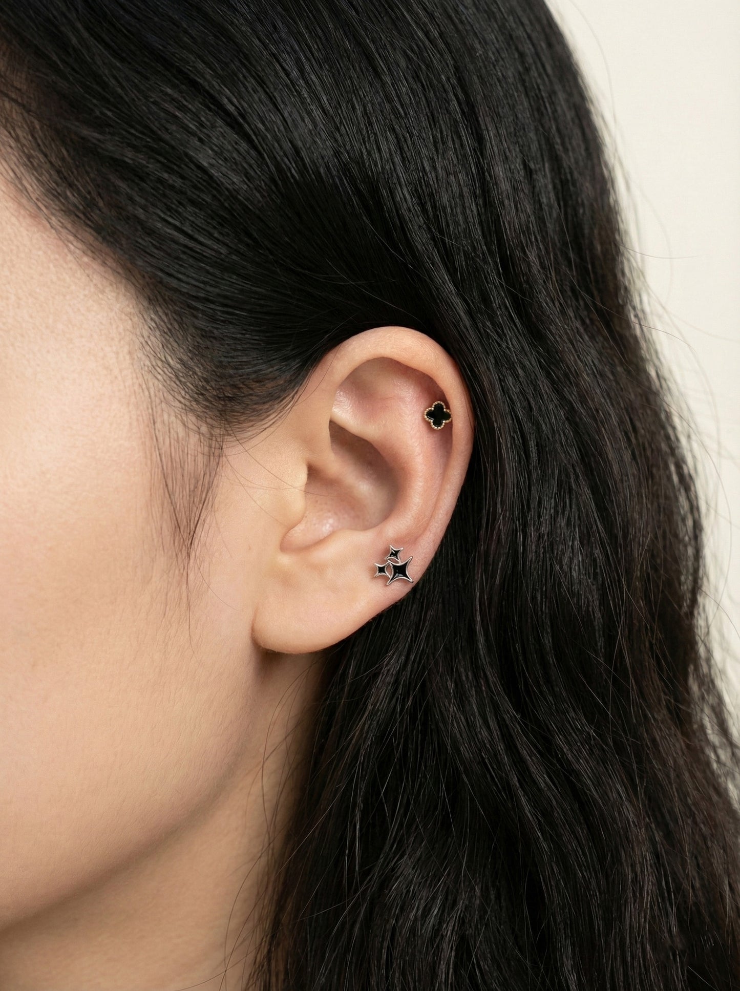 Black mother of pearl clover piercing with gold frame titanium post styled with star stud in ear lobe and conch