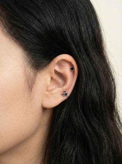 Black mother of pearl clover piercing with gold frame titanium post styled with star stud in ear lobe and conch