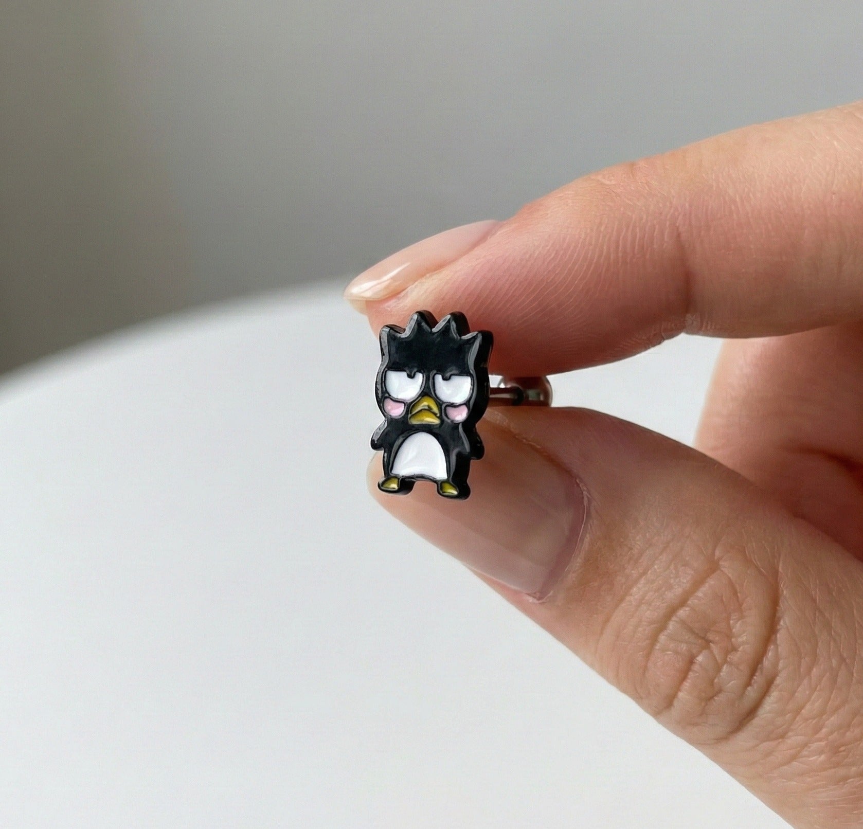 Close-up of Badtz-Maru piercing stud showing detailed facial expression and glossy epoxy finish