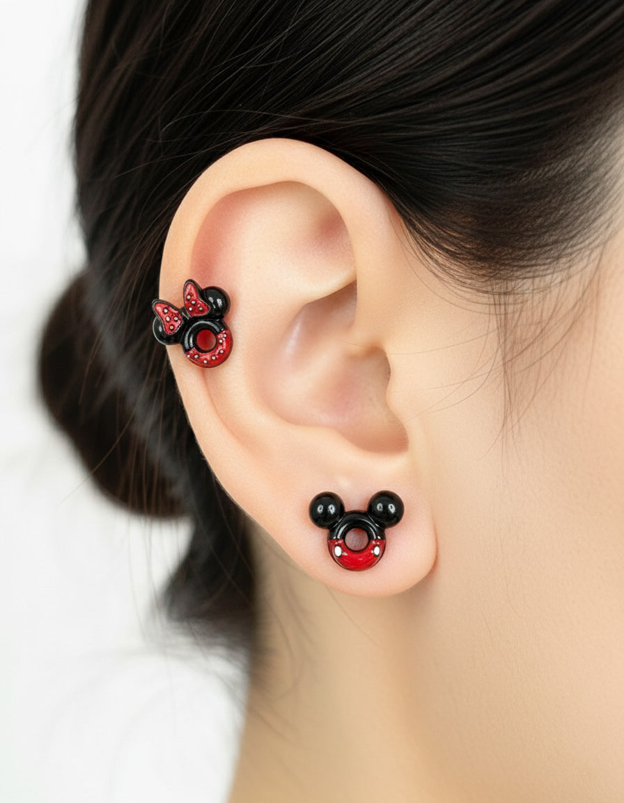 Close-up of a woman wearing mismatched Minnie and Mickey Mouse stud earrings on cartilage and lobe