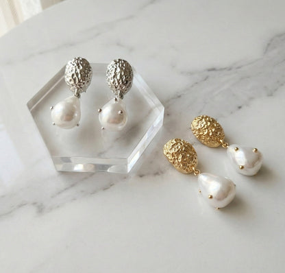 Vintage hammered baroque pearl drop earrings in gold and silver on marble display