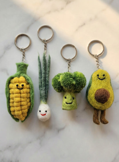 Handmade Nepal wool felt vegetable keychains - corn, scallion, broccoli, avocado on marble background