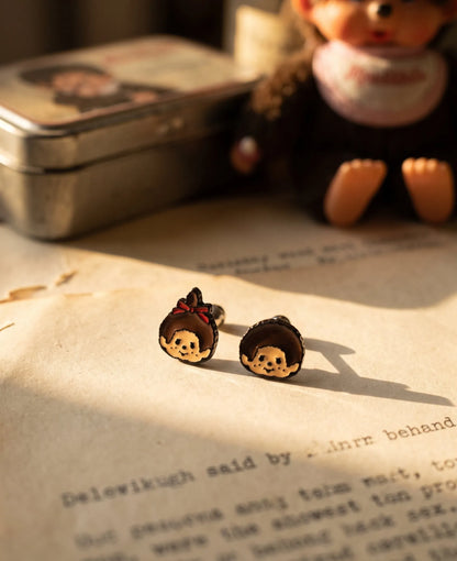 Monchhichi & Kiki hand-enameled enamel stud earrings on vintage book — nostalgic kidult jewelry made in Korea