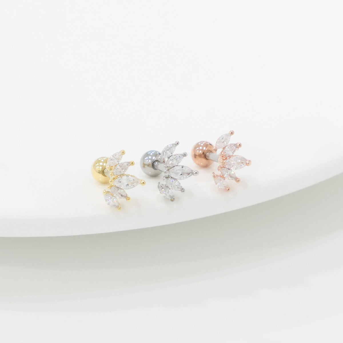 Close-up of three colors of wing marquise stud earrings - gold, silver, rose gold