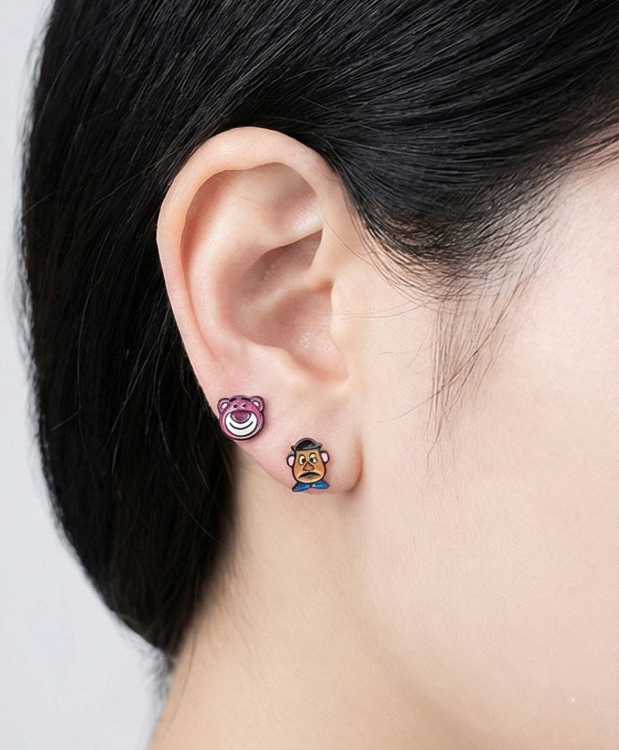 Toy Story character stud earrings on ear showing Lotso bear and Mr Potato Head mix match style