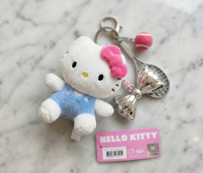 Authentic Hello Kitty plush keychain with silver tennis racket, pink tennis ball, and silver bow charm on white marble background