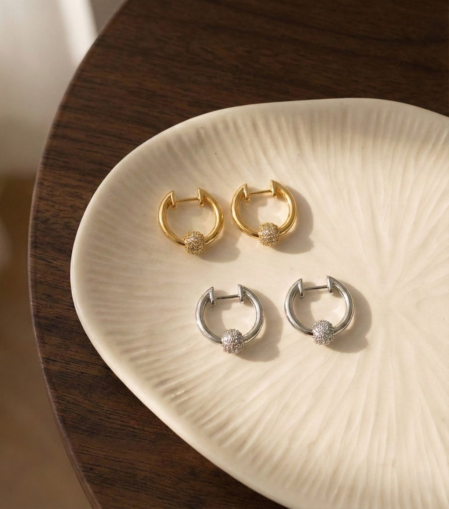 Gold and silver pave ball huggie hoops color comparison flat lay