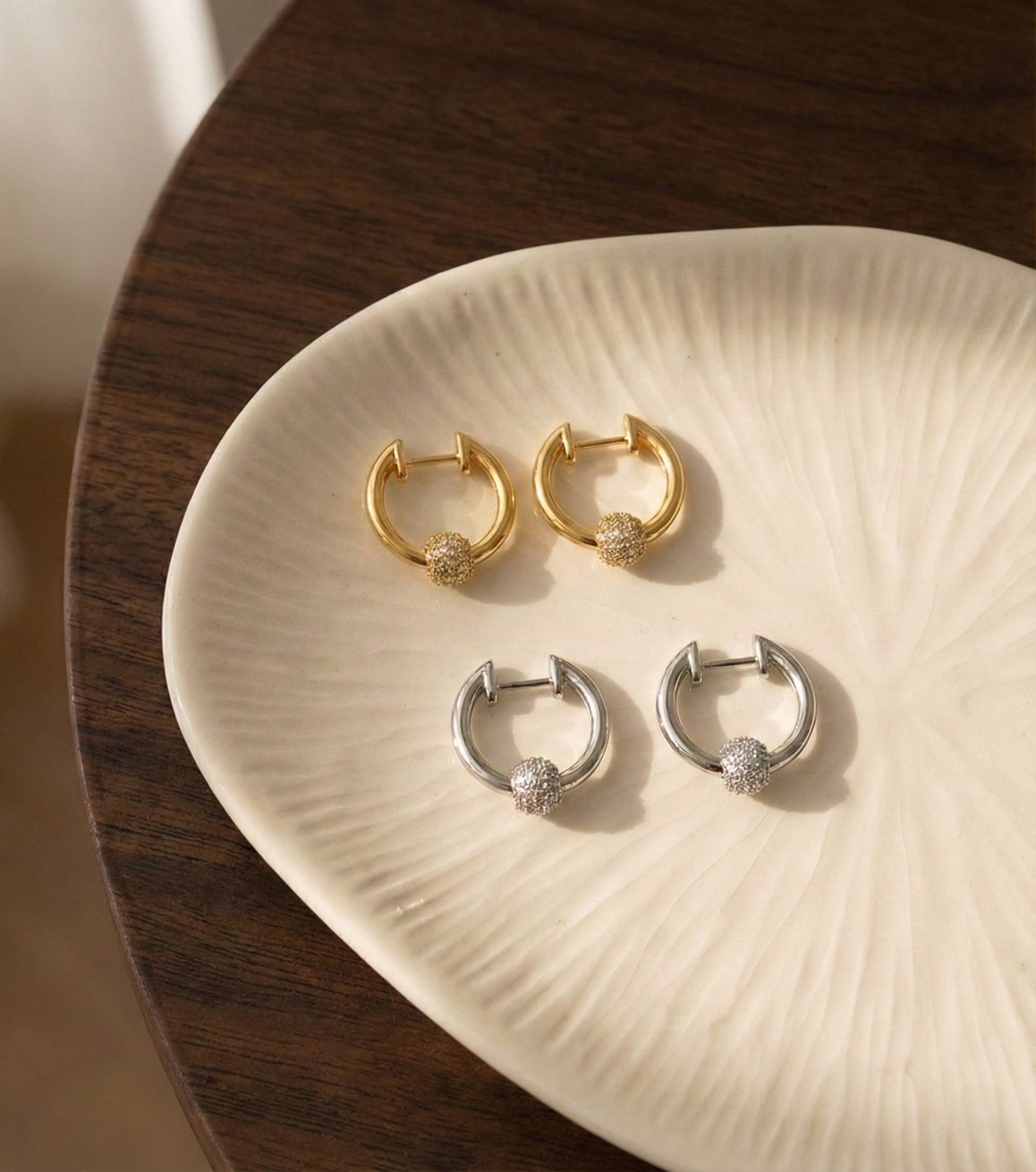 Gold and silver pave ball huggie hoops color comparison flat lay