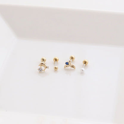 Four-piece barbell ball stud earring set featuring dolphin, whale tail, pearl and basic ball designs on white background