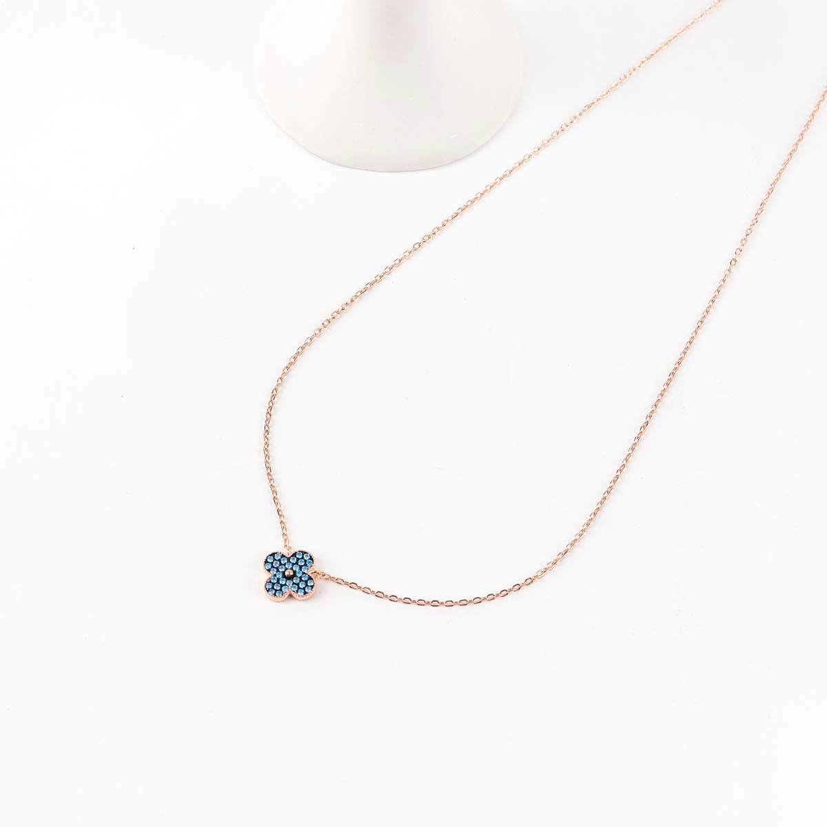 925 sterling silver blue clover necklace with rose gold chain on white background