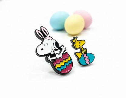Snoopy and Woodstock Easter egg enamel earrings with pastel colored eggs in background
