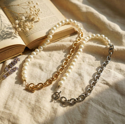 Flat lay of gold and silver half pearl half chain toggle choker necklaces with dried flowers