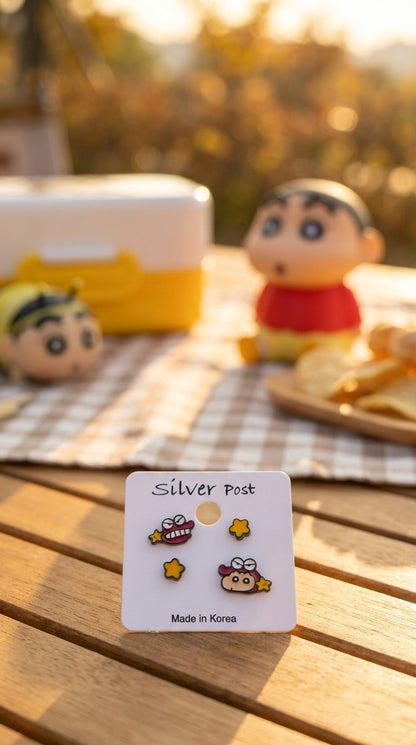 Crayon Shin-chan and Chocobi character earring set with yellow star studs displayed on white card, outdoor natural light setting