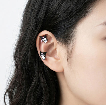 Kuromi character enamel stud earrings on ear showing helix and lobe placement with surgical steel posts