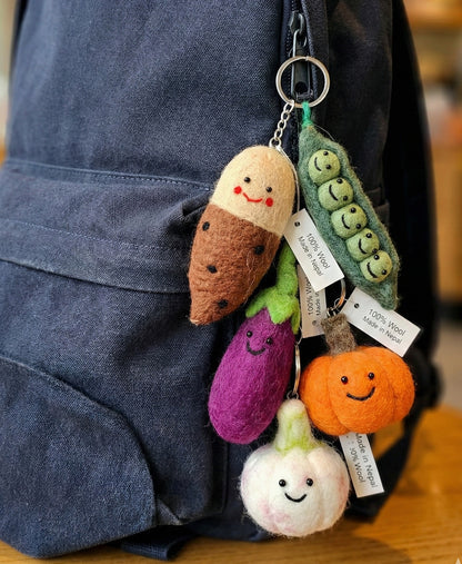 Handmade Nepal wool felt vegetable keychain set hanging on navy blue backpack