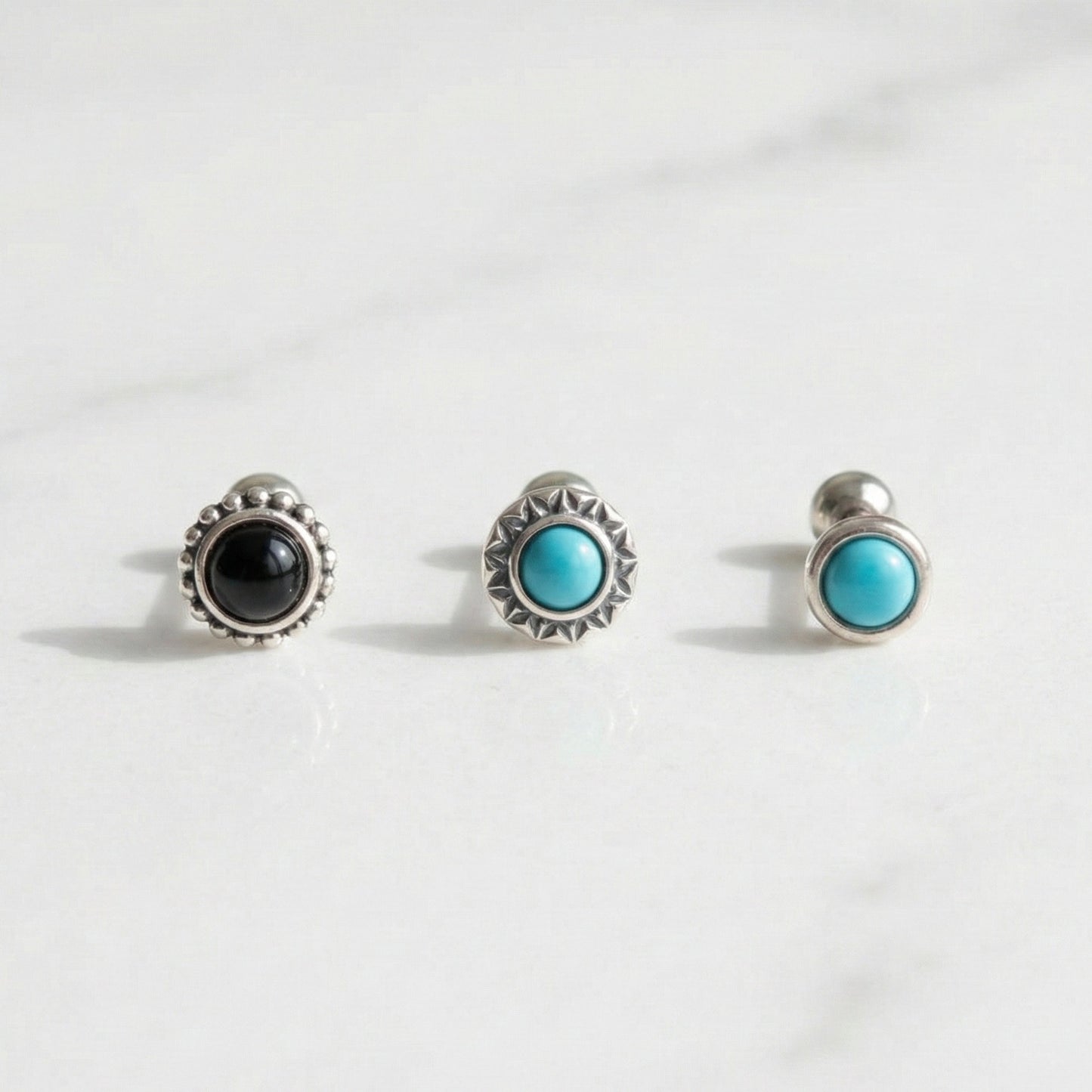Three vintage barbell stud earrings with turquoise and onyx stones on white background