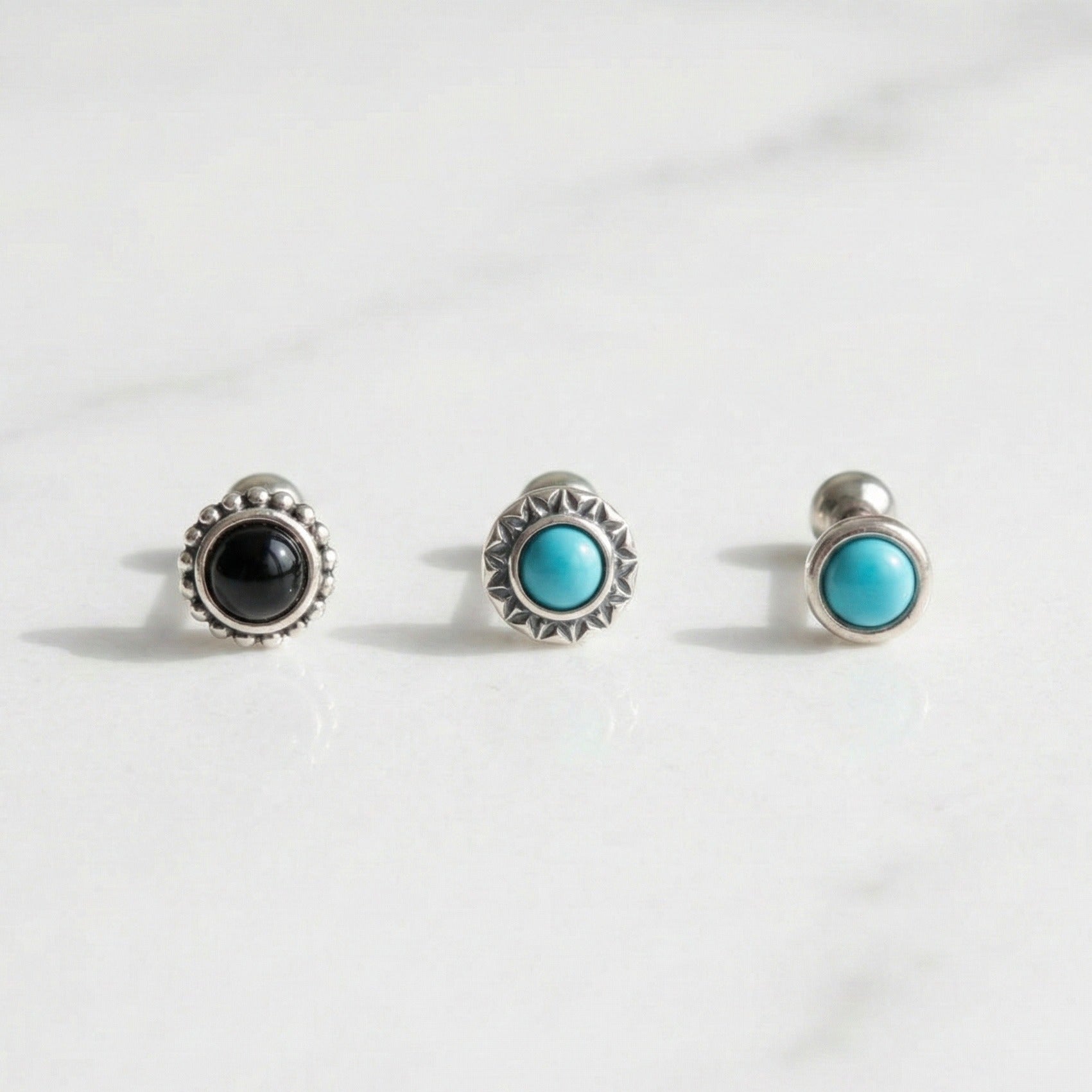 Three vintage barbell stud earrings with turquoise and onyx stones on white background