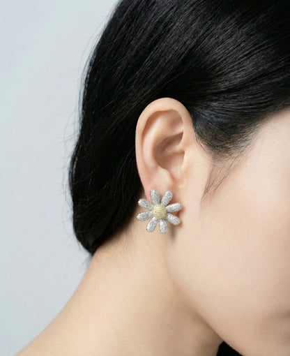 Woman wearing yellow center daisy flower CZ earrings - side profile view showing sparkle and dimension