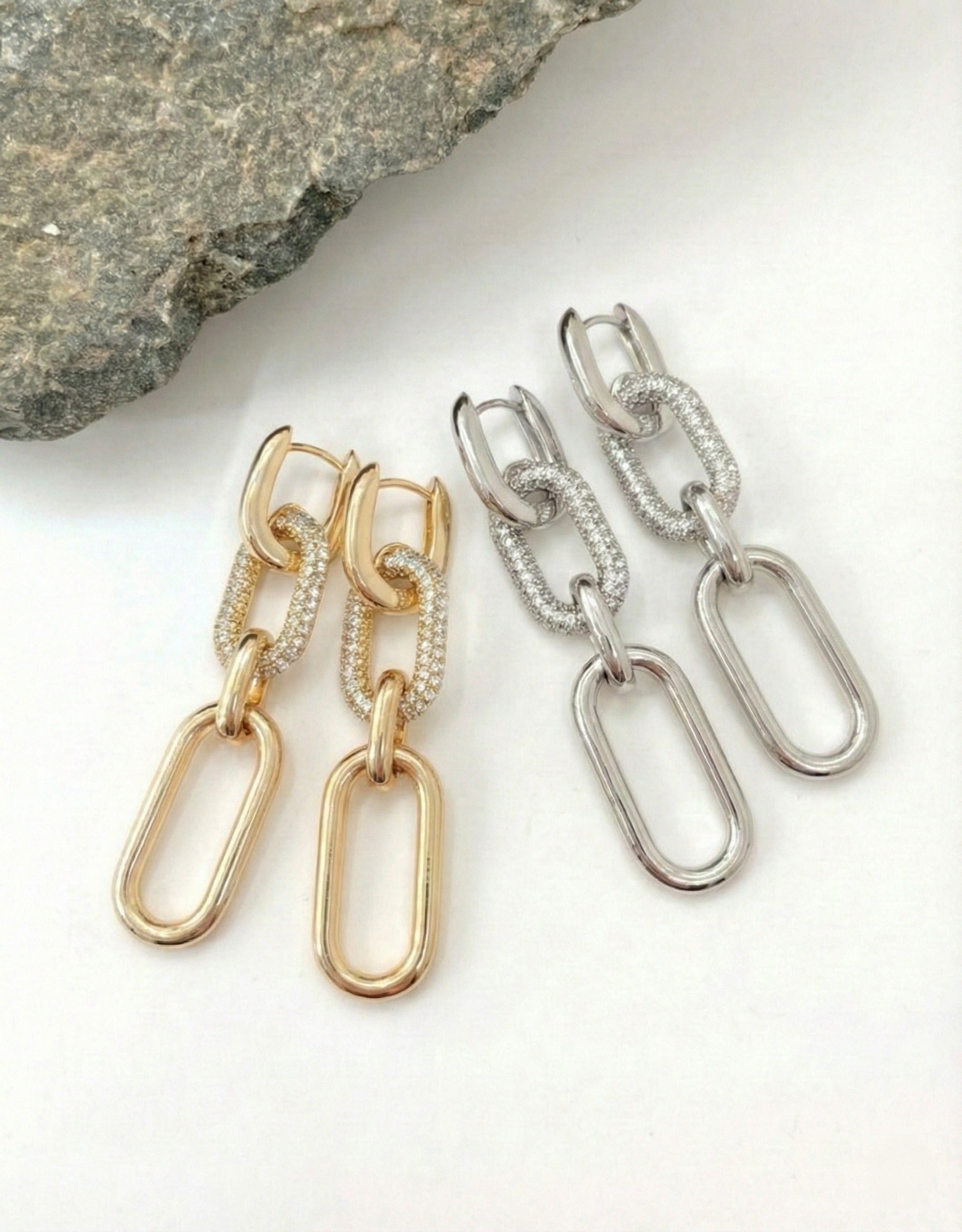 Gold and silver chunky chain link drop earrings with pavé cubic zirconia accents on stone background
