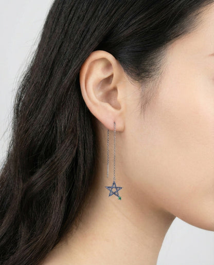 Asymmetrical blue star drop earrings on model ear showing long chain dangle design