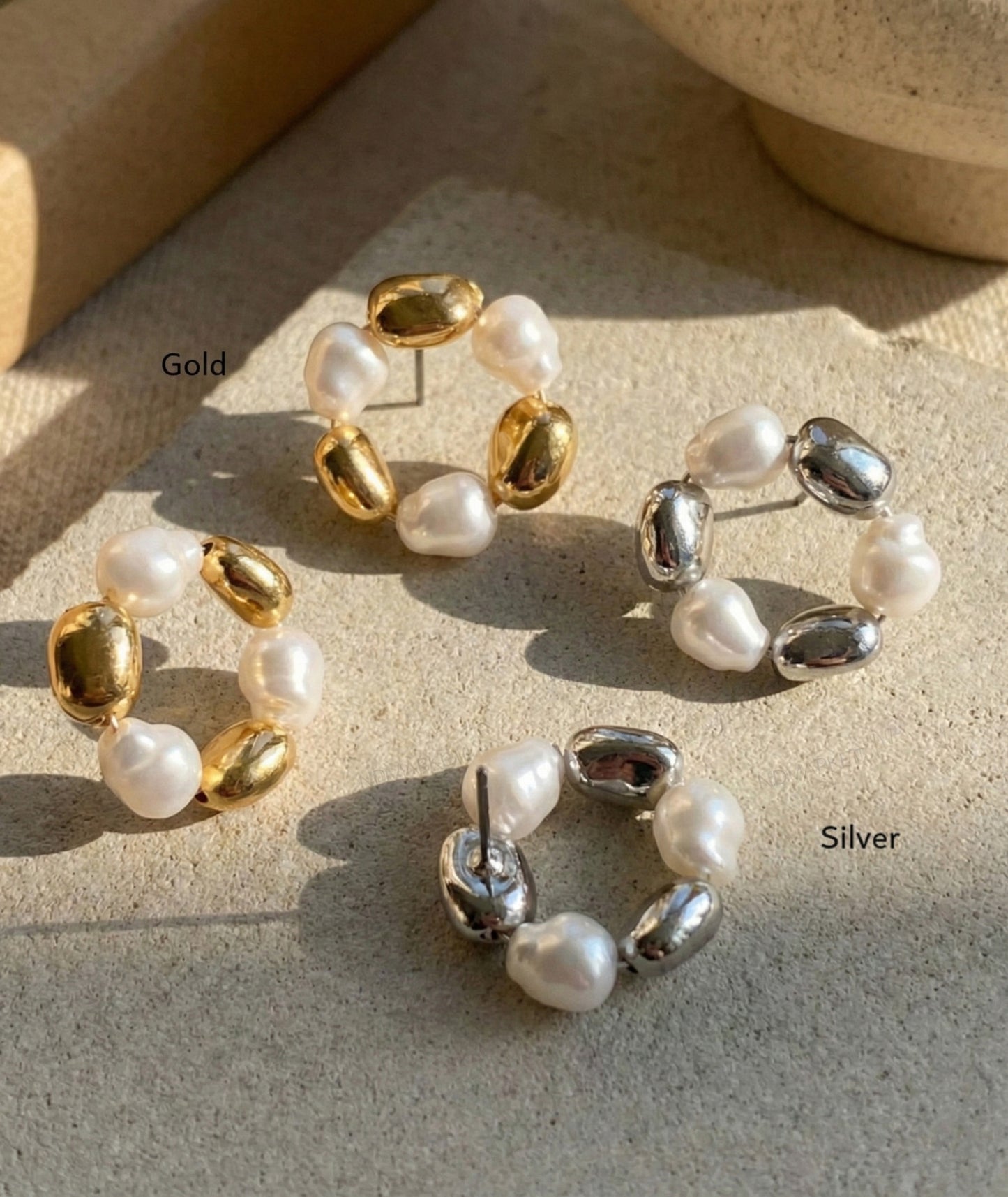  Gold and silver baroque freshwater pearl wreath hoop earrings displayed on stone surface with natural lighting