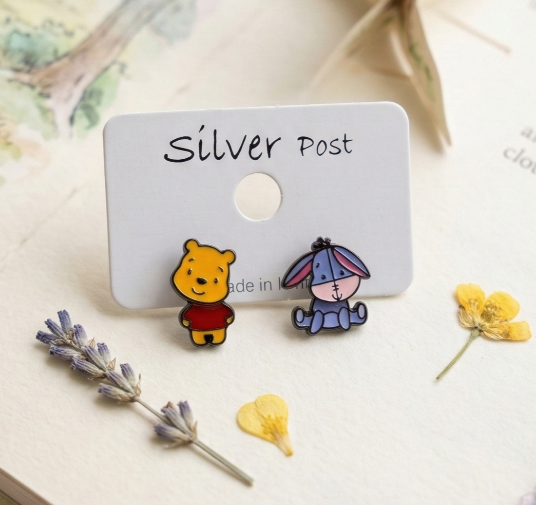 Winnie the Pooh and Eeyore stud earrings on silver post card with lavender and yellow flowers