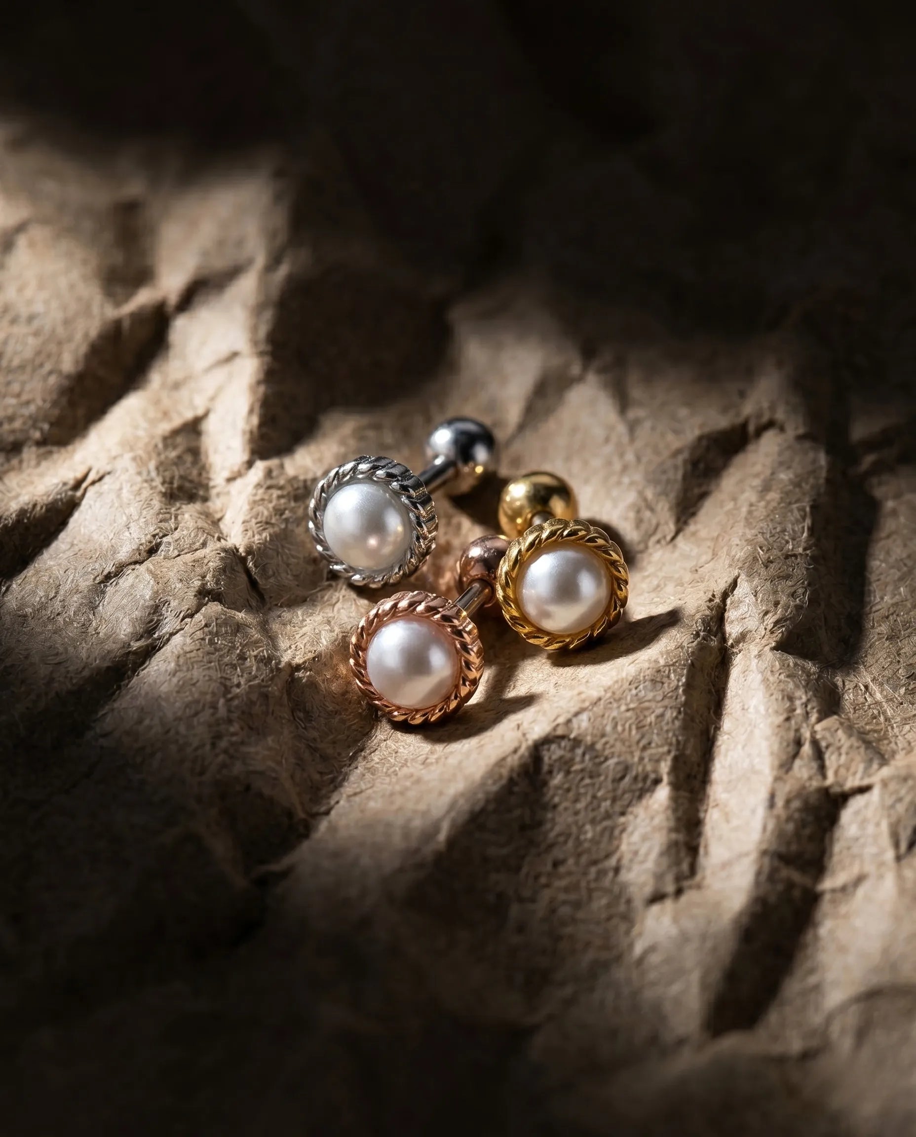 8ttitto8 vintage rope frame pearl barbell piercing studs in silver gold and rose gold displayed on textured stone surface – minimalist ear curation jewelry