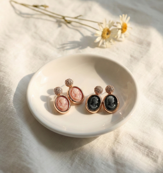 Pink and black vintage cameo drop earrings with pave crystal studs on white ceramic plate
