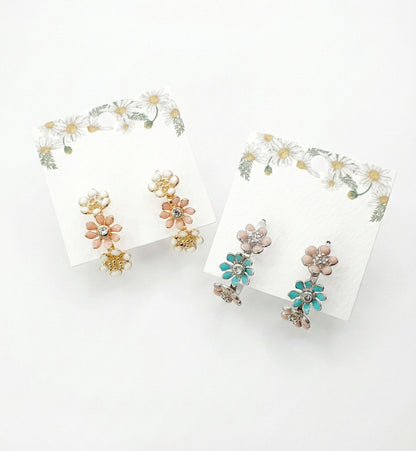 Korean handmade enamel flower hoop earrings in peach blossom and mint garden colors displayed on daisy-decorated cards