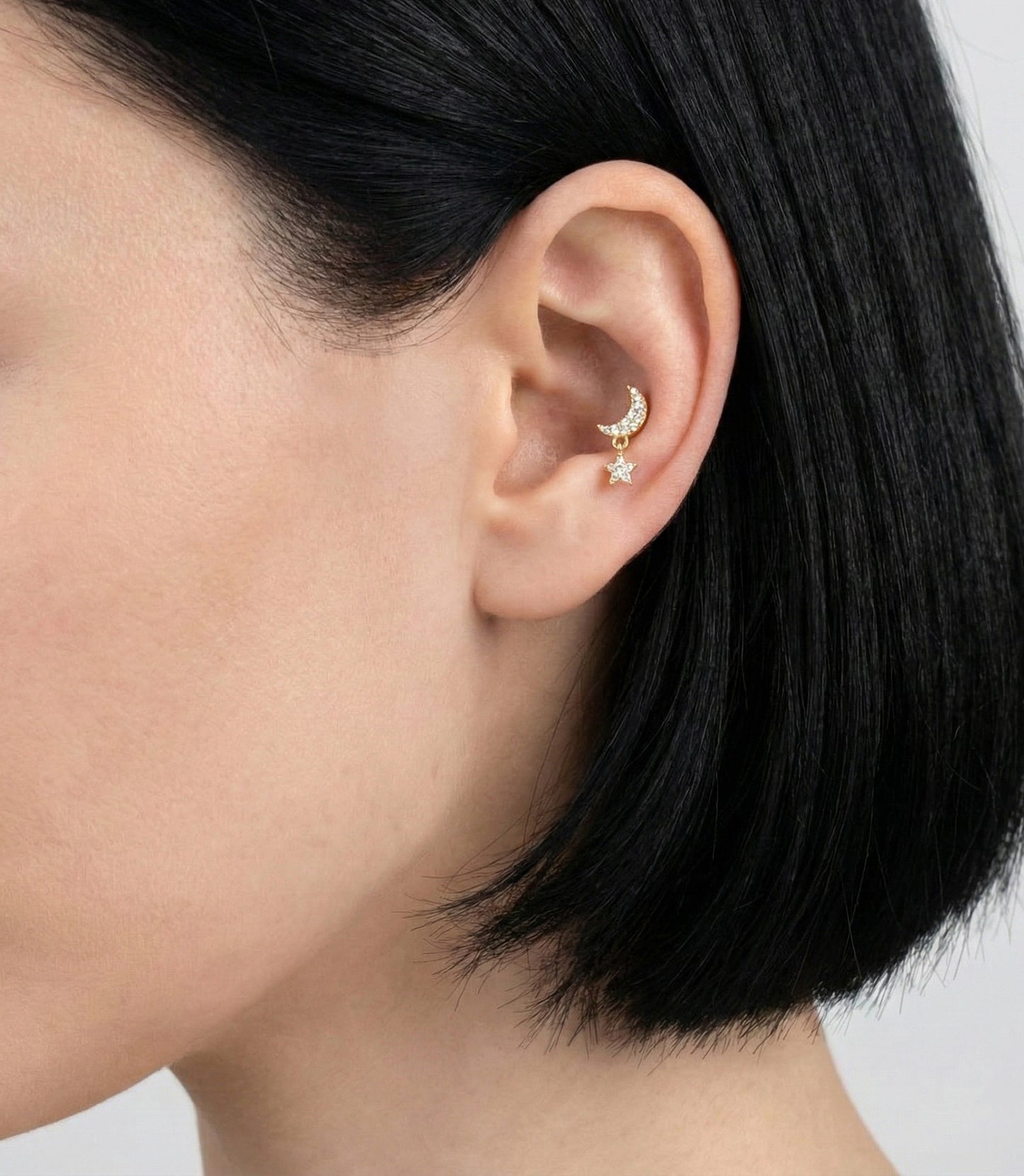 Gold moon & star dangle barbell piercing on inner conch