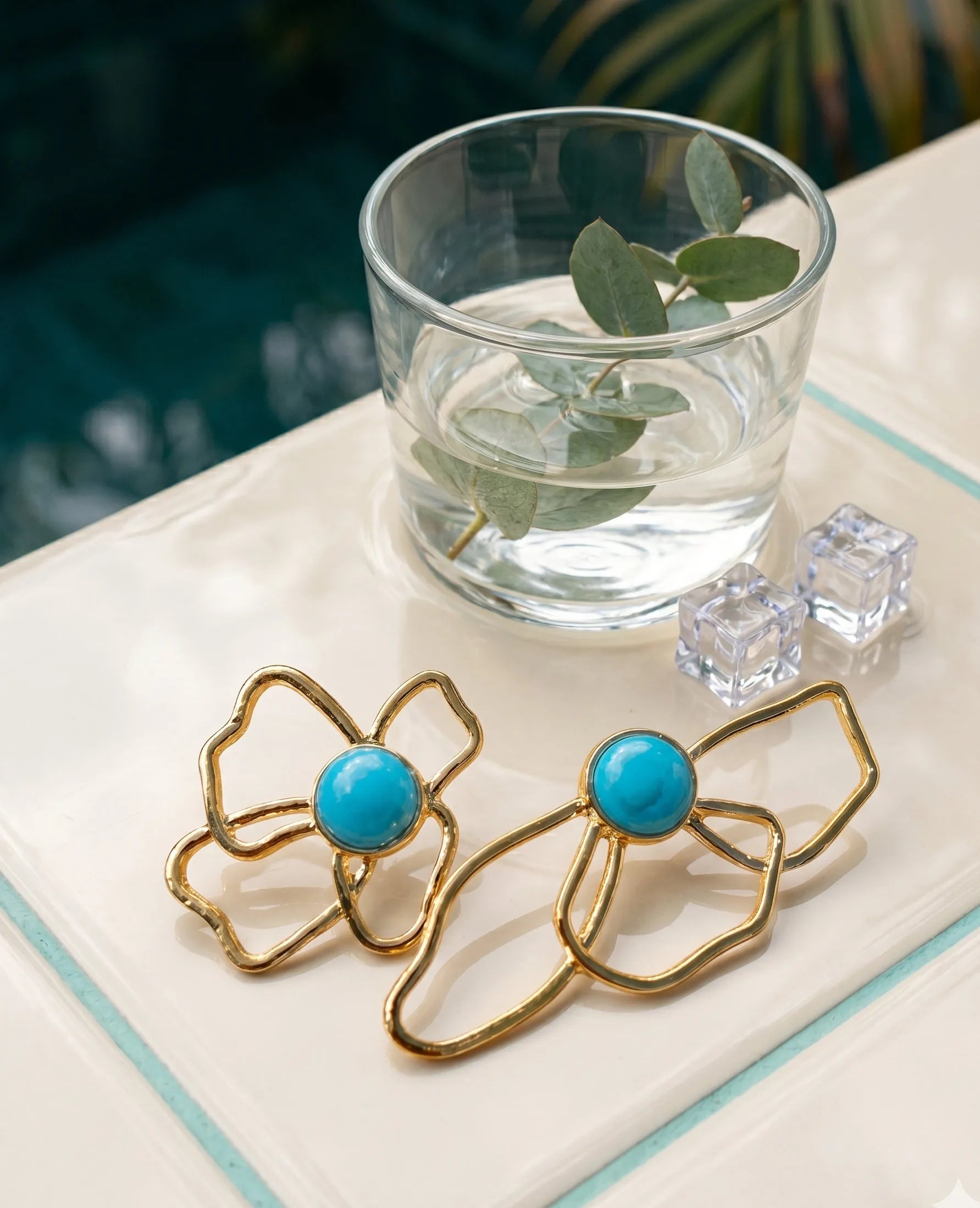 Bold turquoise flower earrings flat lay, asymmetrical gold statement earrings detail shot