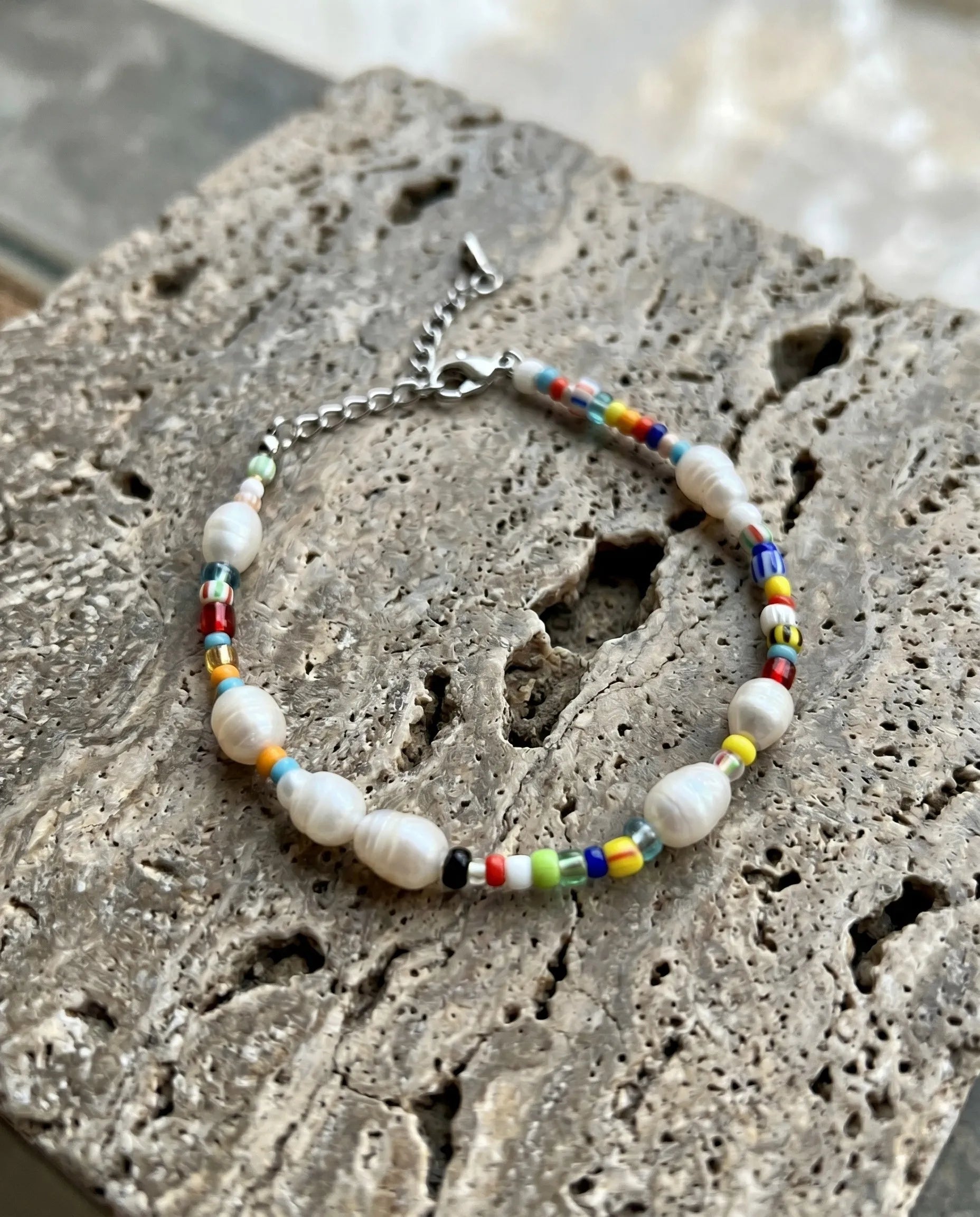 Korean handmade real freshwater pearl bracelet with rainbow Miyuki seed beads surgical steel lobster clasp on stone surface